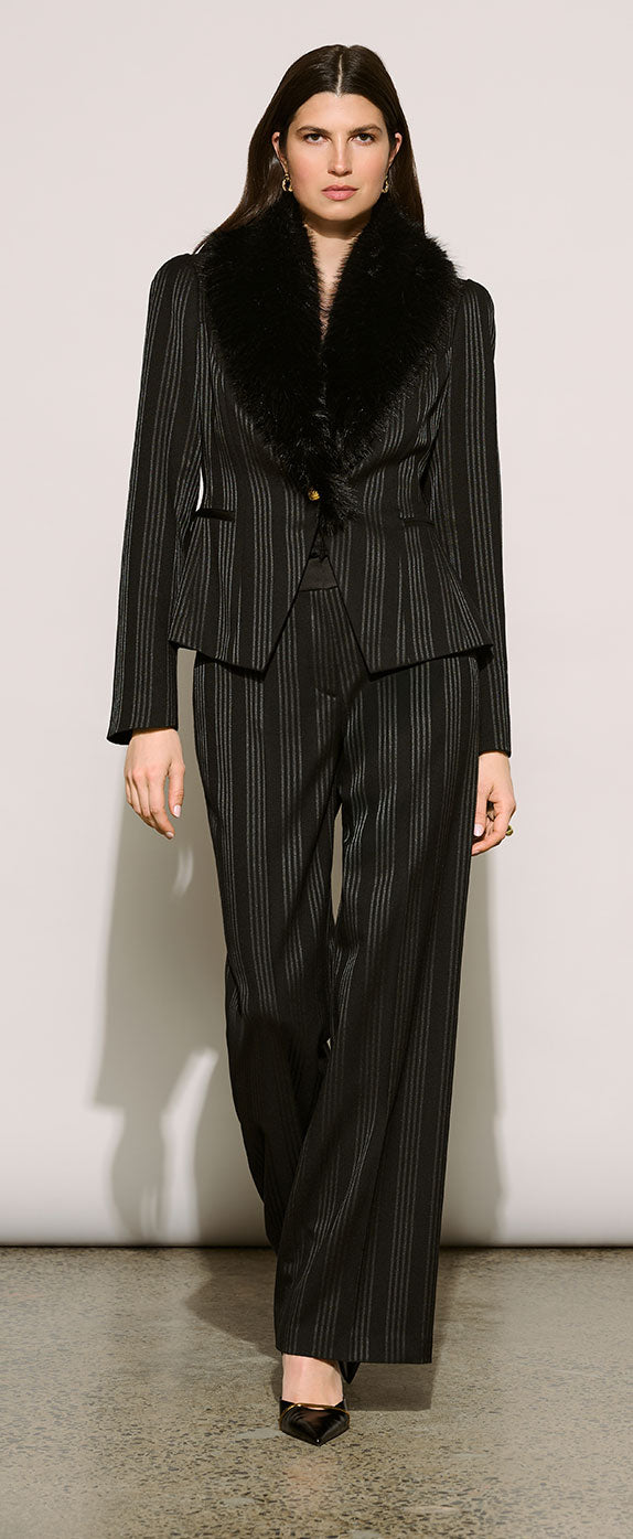A model wearing Joseph Ribkoff Edit 57 black pinstripe suit with a black fur collar