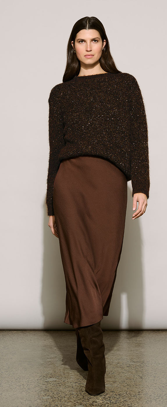 A model wearing Joseph Ribkoff Edit 57 dark brown textured knit sweater and a matching brown satin midi skirt