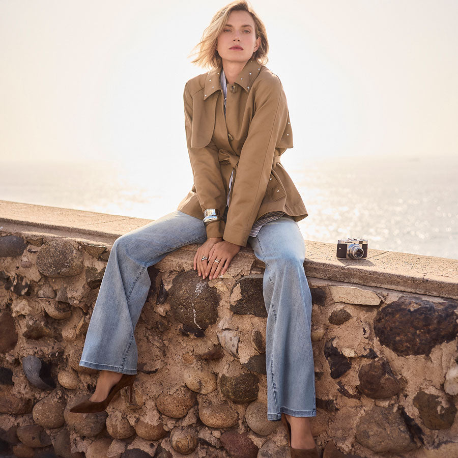 Woman wearing a brown jacket and blue Joseph Ribkoff jeans.